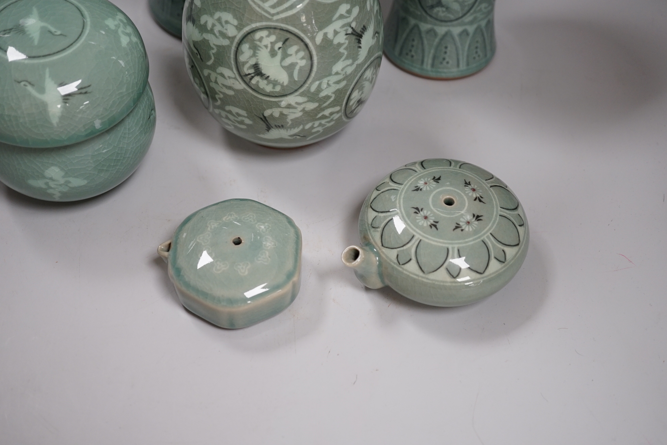 Seven pieces of Korean celadon glazed ceramics including four vases decorated with cranes amongst clouds, the largest 22cm high